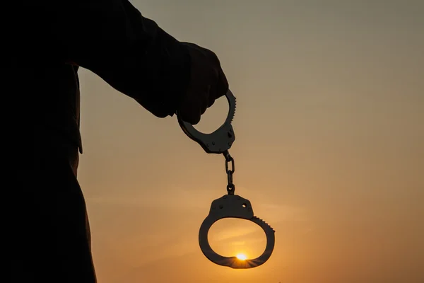 Business Man holding handcuffs after releasing over sunset — Stock Photo, Image