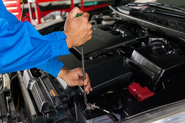 Mekaniker kontrollera och korrigera en trasig bil i bil service garage — Stockfoto