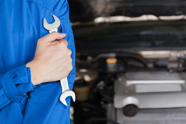Hombre en uniforme técnico azul va a reparar para el mantenimiento del coche . —  Fotos de Stock