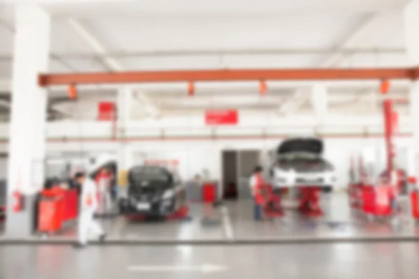 Suddig av inuti bil garage med bilar är under underhåll — Stockfoto