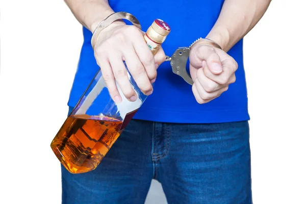 Człowiek ręcznie noszenia picia alkoholu z kajdankami - pijani kierowcy, koncepcja efekt uzależnienia od alkoholu (z naciskiem na kajdanki) — Zdjęcie stockowe