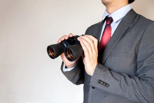 Nahaufnahme eines Geschäftsmannes, der mit einem Fernglas nach etwas sucht. — Stockfoto