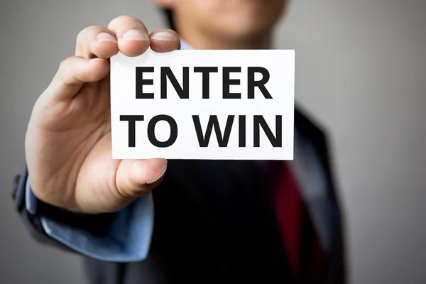 Businessman presenting 'Enter to Win' word on white card