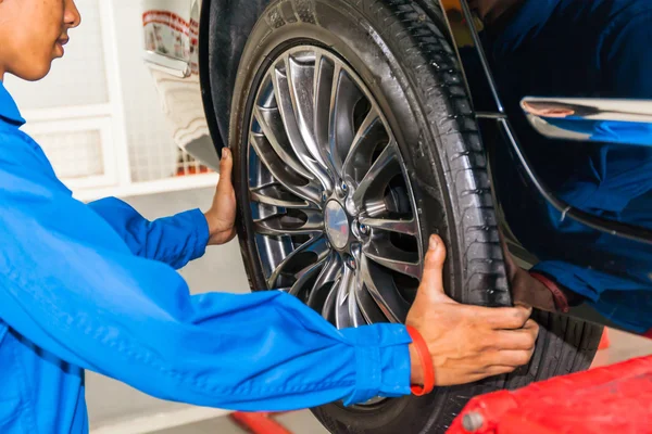 Механическое снятие или замена колеса автомобиля в гараже обслуживания автомобилей — стоковое фото