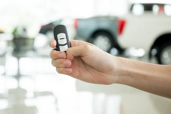 Mains humaines donnant pouces vers le haut avec la clé de voiture dans la salle de tir de voiture — Photo