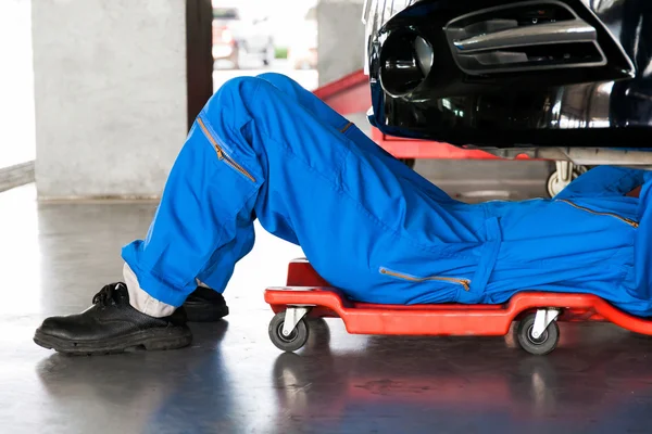 Makinist aşağı yalan ve arabanın altında çalışma mavi üniformalı