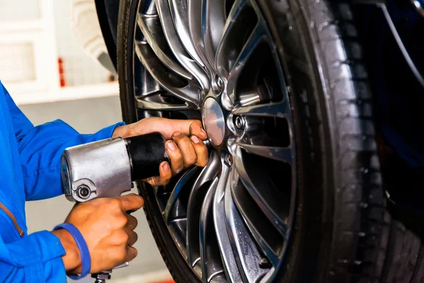 Mekaniker skruva eller skruva bil hjul bil service garage — Stockfoto