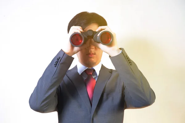 Hombre de negocios asiático que busca algo con prismáticos como oportunidades de negocio / empleos / nuevo mercado - concepto de descubrimiento de problemas de negocio . —  Fotos de Stock