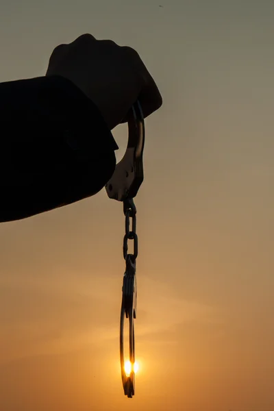 Uomo d'affari che tiene le manette dopo il rilascio sopra il tramonto — Foto Stock
