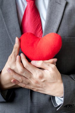 Onun göğsünde onun takım elbise - crm, hizmet zihin iş kavramı kırmızı kalp tutunarak şefkat gösteren işadamı