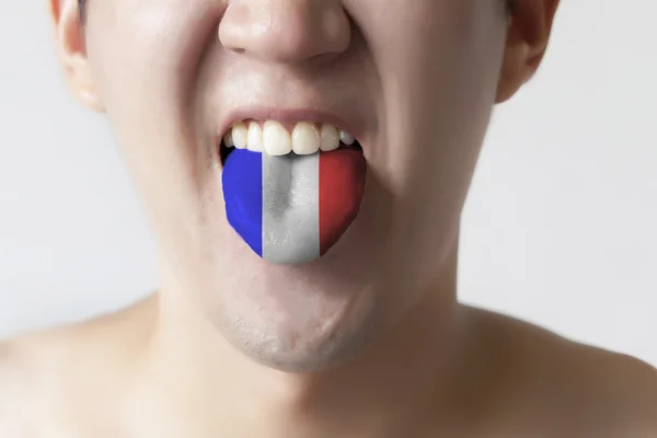 Σημαία της Γαλλίας ζωγράφισε στη γλώσσα ενός ανθρώπου - που δείχνει την γαλλική γλώσσα και μιλώντας — Φωτογραφία Αρχείου