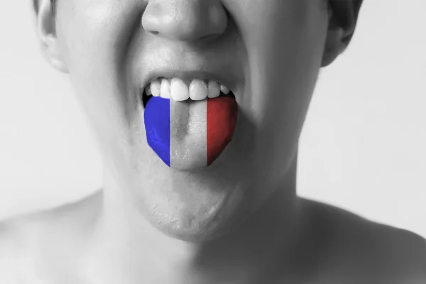 Bandera de Francia pintada en la lengua de un hombre - que indica el idioma francés y habla en blanco y negro —  Fotos de Stock