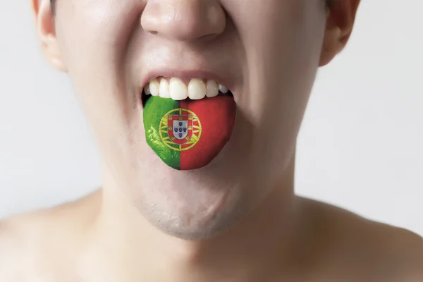 Bandeira de Portugal pintada na língua de um homem - indicando a língua portuguesa e falando  . — Fotografia de Stock