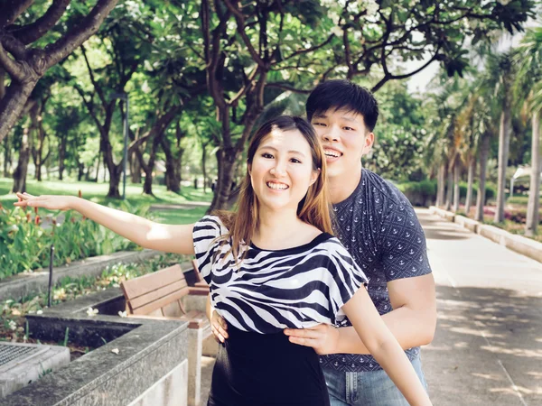 Casal asiático estava tentando levantá-la e se divertir no parque público . — Fotografia de Stock