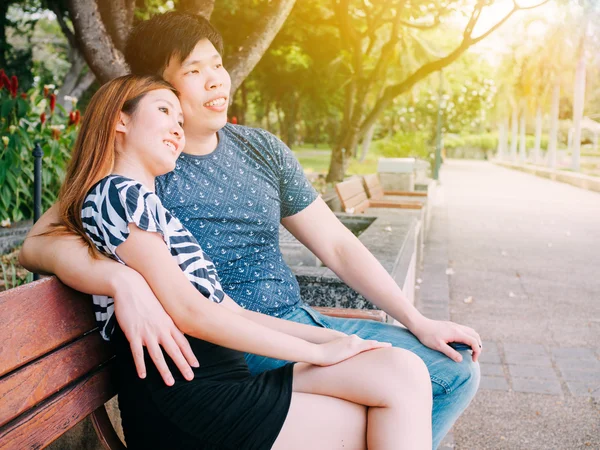 Asiático casal sentado no banco no parque juntos — Fotografia de Stock