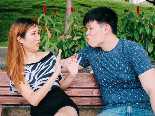 Молодой азиат пытается поцеловать девушку, но ему отказывают. — стоковое фото