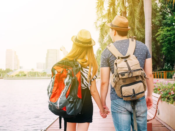 Couple travelers walking and holding hands together - Journey of love and travel