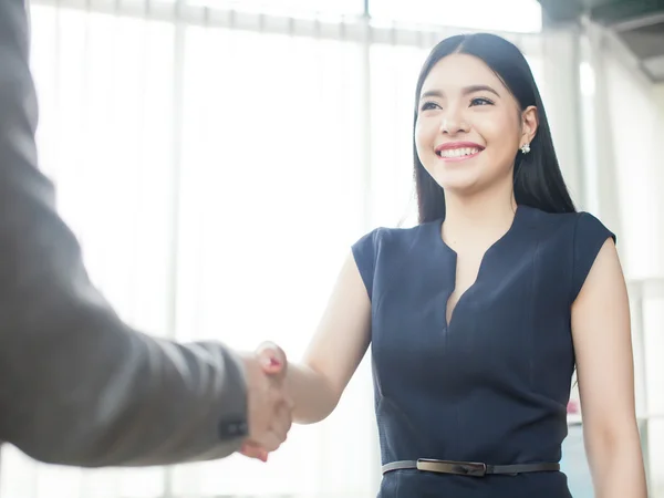 Smart and confident Asian businesswoman smiling and shaking hand