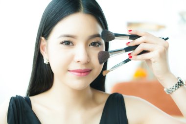 Asyalı kadın fırçalar - güzellik makyaj kavramı holding