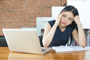 Asyalı kadın düşünme ve Modern ofis içinde Laptop önünde ciddi