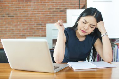 Asyalı kadın düşünme ve Laptop önünde ciddi