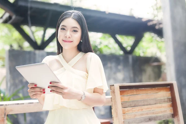 Beautiful Asian woman playing with her tablet — Stock Photo, Image