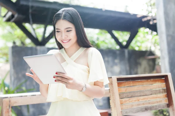 Hermosa mujer asiática jugando con su tablet — Foto de Stock