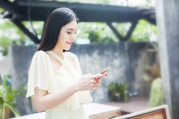 Hermosa mujer asiática jugando con su teléfono — Foto de Stock