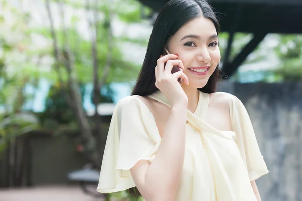 Красивая азиатка разговаривает по телефону — стоковое фото