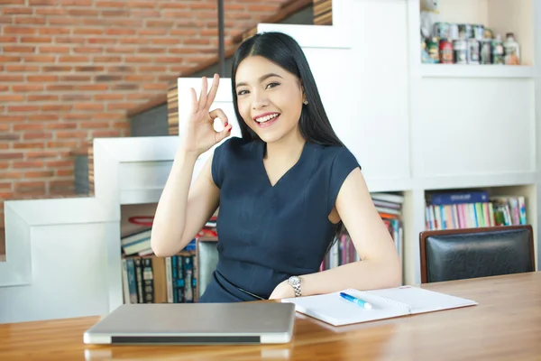 亚洲青年女子坐在便携式计算机和 ok 的手势 — 图库照片