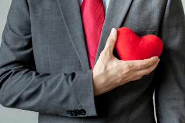 Onun göğsünde onun takım elbise - crm, hizmet zihin iş kavramı kırmızı kalp tutunarak şefkat gösteren işadamı
