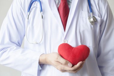 Şefkat ve ceketini göğsünde kırmızı kalp tutunarak destek gösteren doktor