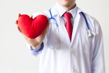 Şefkat ve kırmızı kalp tutan destek gösteren doktor
