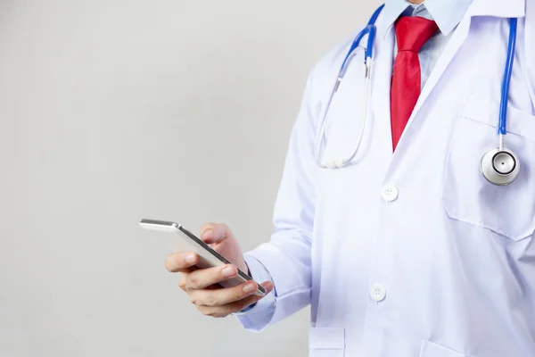 Médico usando telefone em fundo isolado branco — Fotografia de Stock