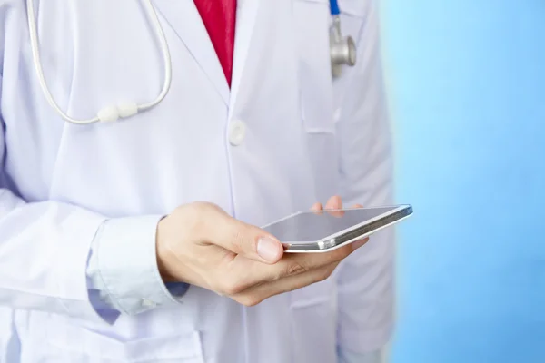 Arzt mit Telefon in blau isoliert Hintergrund — Stockfoto