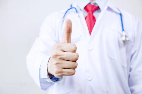 Close up of doctor in coat with stethoscope giving thumbs up in white isolated background. — Stock Photo, Image