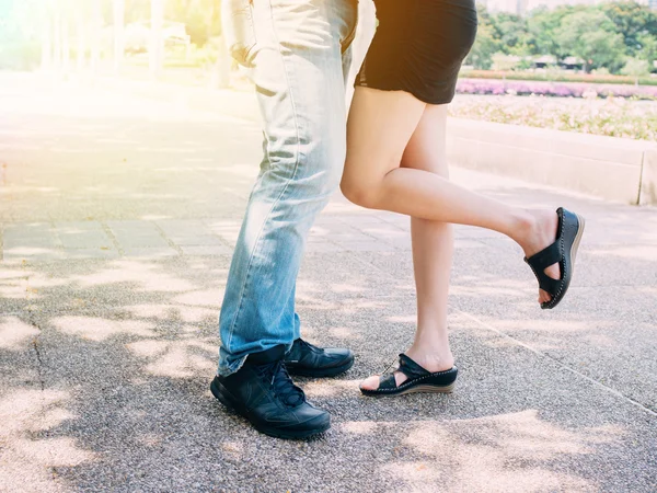 Casal no relacionamento beijando juntos, enquanto uma menina levantando a perna . — Fotografia de Stock