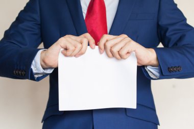 İşadamı beyaz arka plan üzerinde boş kağıt parçalıyor