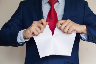 İşadamı beyaz arka plan üzerinde boş kağıt parçalıyor