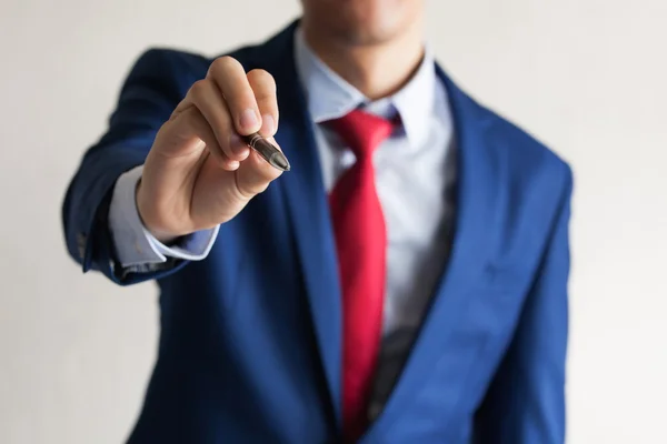 Nahaufnahme eines jungen Geschäftsmannes, der mit der Hand in die Luft schreibt, während er auf dem Touchscreen schreibt — Stockfoto