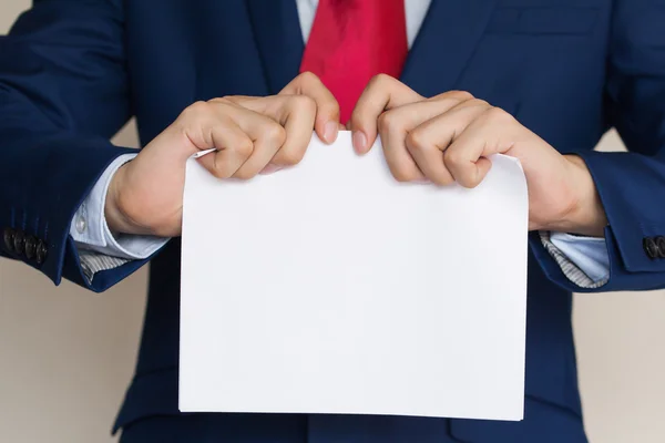 Geschäftsmann reißt leeres Papier auf weißem Hintergrund auseinander — Stockfoto