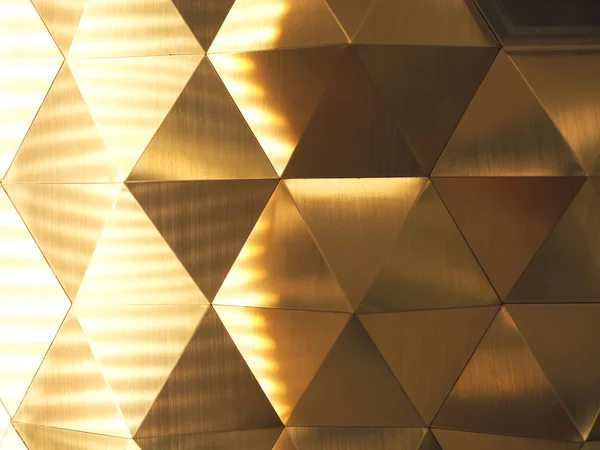 Fondo abstracto geométrico polivinílico amarillo dorado con iluminación a la izquierda — Foto de Stock