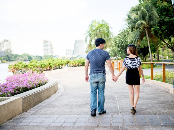 Asiático casal de mãos dadas andando no parque — Fotografia de Stock