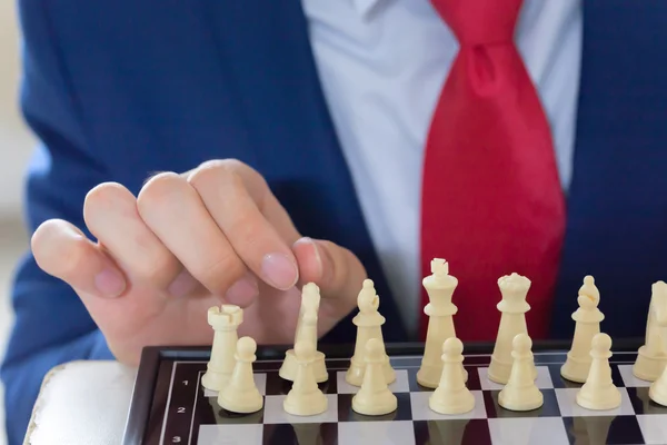 Hombre de negocios moviendo figura de ajedrez con estrategia y pensamiento de liderazgo de equipo —  Fotos de Stock