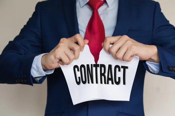 Businessman tearing CONTRACT apart on white background — Stock Photo, Image