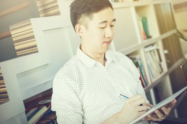 Oturma ve dizüstü (Vintage sesi yazma genç casual Asyalı adam).