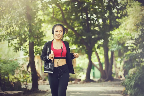 Mulher asiática corredor ouvindo música e correndo ao ar livre — Fotografia de Stock