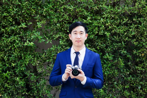 Azjatycka profesjonalnego fotografa robić zdjęcia w tle zielony — Zdjęcie stockowe