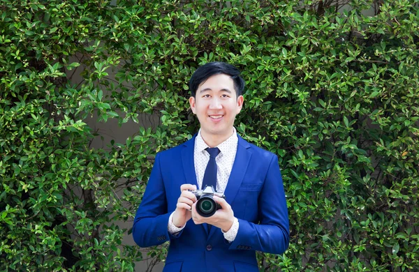 Sonriente asiático profesional fotógrafo holding vintage cámara — Foto de Stock