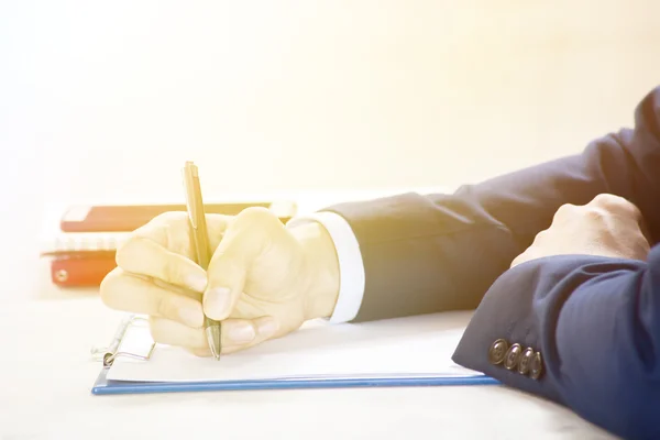 Closeup of Businessman writing on paper on notepad — Stock Photo, Image